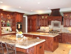 Alder cabinetry with detailed carvings and two islands