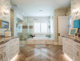 Master bath with chevron wood floor, white cabinets and garden tub