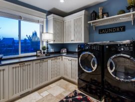 Laundry room featuring white cabinetry with bead board doors and drawers with dark glaze