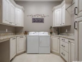 Laundry room with white, glazed and distressed cabinetry