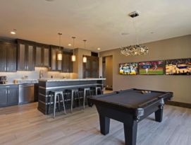 Kitchenette/bar with pool table and wall of three tvs.