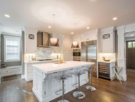 White kitchen cabinetry and counter tops with hardwood floor