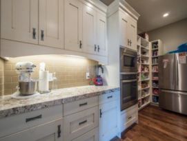walk in pantry with white shaker style cabinetry