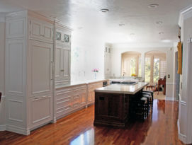 White kitchen cabinetry with dark wood island.