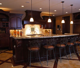 Dark alder wood kitchen with beautiful carvings on corbels and hood.