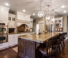 white kitchen cabinetry with dark island and floor