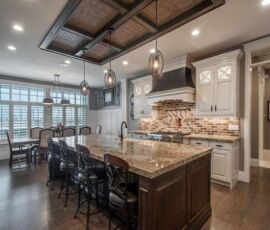 White kitchen cabinetry with dark island