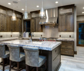 Gray on gray kitchen with quarter sawn oak cabinets, stainless mesh inset on top doors and stainless hood.