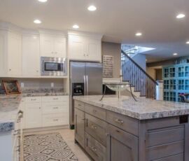 White kitchen cabinetry with gray island and gray granite counter tops