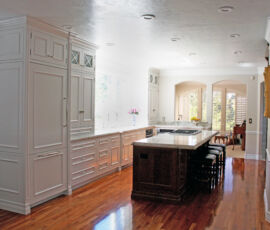 White kitchen cabinetry with dark wood island.